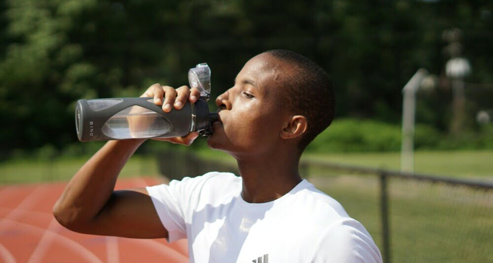 A man drinking water out of a Plastic Bottle