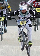A young boy on his BMX Bike No.5  just gone over a hump with his front wheel in the air.