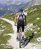 Man on Bike on a stoney Track heading downhill  from the Mountains
